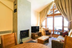 a living room with a fireplace and a tv at Les Terrasses d'Eos, 1-bed apartment with fireplace, Ski in, Ski out in Flaine