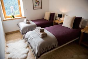 two beds in a room with towels on them at 'Petite Ferme Les Bouts' Aptartment, sleeps 6, Nr Morzine in La Côte dʼArbroz