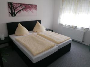 a bedroom with a bed with white sheets and a window at Sleep & Living FeWo Rheinsheim in Philippsburg