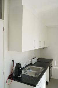 uma cozinha com um lavatório e uma bancada em Casa Do Tio Arménio em Ponte de Lima
