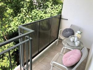 a balcony with two chairs and a table with a pink pillow at Apartament Kamienny Potok Sopot in Sopot