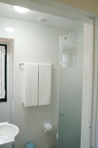 een witte badkamer met een douche en een wastafel bij Casa Do Tio Arménio in Ponte de Lima