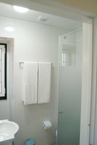 a white bathroom with a shower and a sink at Casa Do Tio Arménio in Ponte de Lima +29 photos