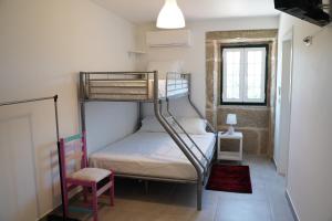 a small room with a bunk bed and a chair at Casa Do Tio Arménio in Ponte de Lima