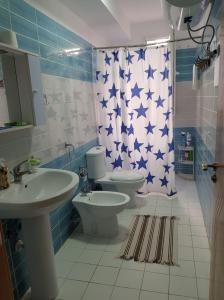 a bathroom with a toilet and a sink and a shower curtain at Seaside Nest Shengjin in Shëngjin +10 photos
