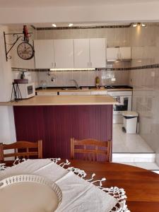La AsomadaにあるVV - Casa Para Tiの白いキャビネットと木製テーブル付きのキッチン