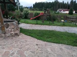 a playground with a red slide in a yard at Farma Ranch Jelemek in Nebahovy