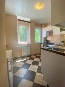 an empty kitchen with a checkered floor at Balian apartman in Siófok