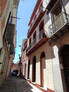 un callejón en una ciudad con un edificio con balcones en Appartamento Marta, en Iglesias