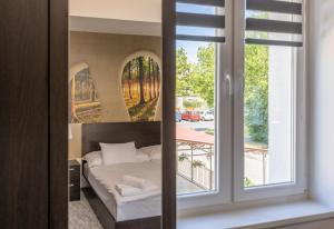 sypialnia z łóżkiem i oknem w obiekcie Panzió 81 w Hajduszoboszlo