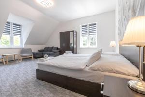 biała sypialnia z dużym łóżkiem i kanapą w obiekcie Panzió 81 w Hajduszoboszlo