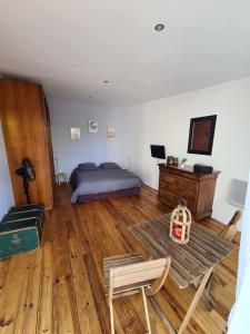 sypialnia z łóżkiem i drewnianą podłogą w obiekcie Dépendance Spacieuse & Cosy Entre et Mer avec Spa w mieście Landéda