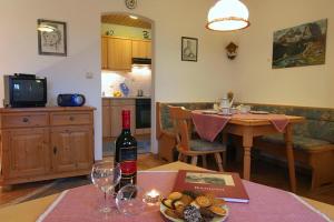Sala de estar con mesa y botella de vino en Haus Unterwegscheid Ferienwohnungen en Ramsau