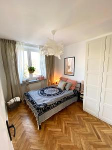 um quarto com uma cama e piso em madeira em Apartament Jan III Sobieski em Rzeszów
