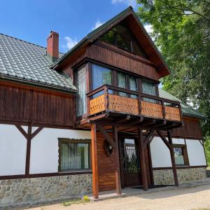 a house with a balcony on top of it at Kurzacka Chata in Szklarska Poręba