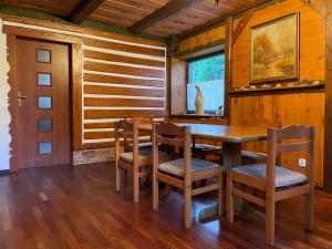 a dining room with a wooden table and chairs at Kurzacka Chata in Szklarska Poręba