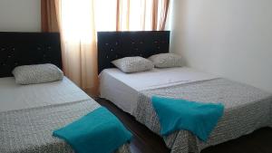 two beds in a room with blue pillows on them at Rix Hostel in Kyrenia