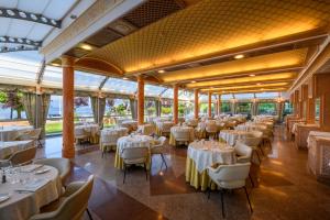a banquet hall with white tables and chairs at Hotel Astoria in Stresa