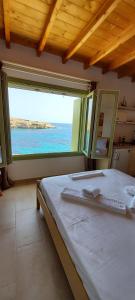 a bedroom with a bed with a view of the ocean at Remezzo Kimolos in Kimolos