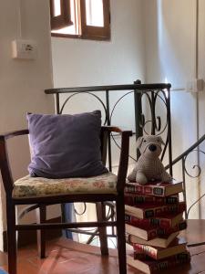 a chair with a pillow and a stack of books at La casetta del frontone in Cetona