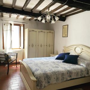a bedroom with a large bed with blue pillows at La casetta del frontone in Cetona