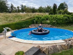 a woman and a child in an inflatable pool at Ferienwohnung Kuhn in Rhumspringe