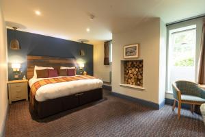 a hotel room with a large bed and a chair at The Partridge, Stretton in Stretton