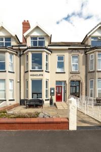 a house with a bench in front of it at Charles Alexander Short Stay - Highcliffe Apartments in Cleveleys