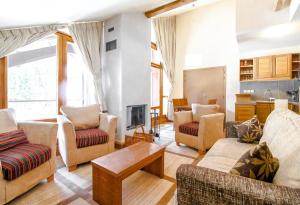 ein Wohnzimmer mit Sofas, Stühlen und einem Tisch in der Unterkunft Cosy, modern 2-bed with fireplace & beautiful views in Flaine