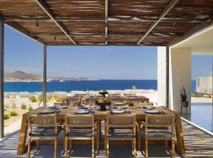 a dining room with a large wooden table and chairs at Domes White Coast Milos, Adults Only - Small Luxury Hotels of the World in Mytakas