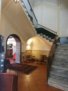 un vestíbulo con escalera, mesa y sillas en Hotel Fiorentina en Nápoles