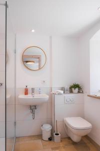 La salle de bains est pourvue d'un lavabo et d'un miroir. dans l'établissement Gehobenes Ambiente in historischer Wohnung, à Walting