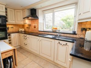 a kitchen with white cabinets and a window at Pen-y-Craig in Rhyl