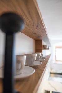 une rangée de tasses et d'assiettes sur un comptoir dans l'établissement Gehobenes Ambiente in historischer Wohnung, à Walting