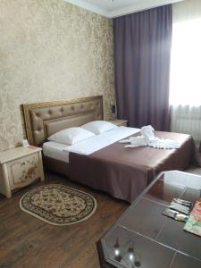 ウーマニにあるUman Hotelのベッドとテーブルが備わるホテルルームです。