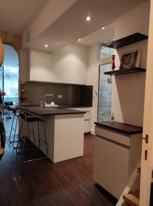 a kitchen with white cabinets and a black counter top at Studio Bordeaux in Bordeaux