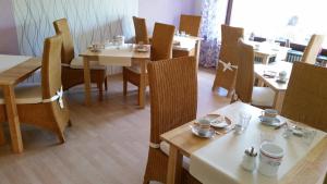a dining room with wooden tables and chairs and tables and chairsktop at Pension Döser Strand in Cuxhaven