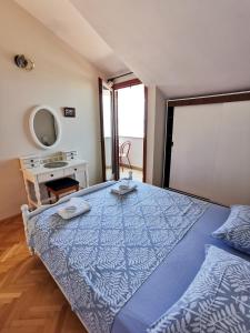 a large blue bed in a room with a mirror at Apartmani Denis Vela in Podgora