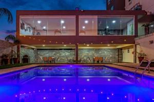 une maison avec une piscine la nuit dans l'établissement CHN Hotel Monterrey Aeropuerto, Trademark by Wyndham, à Monterrey