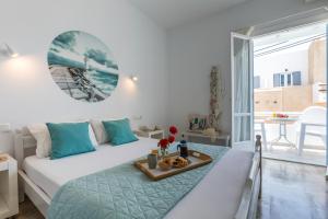 Un dormitorio con una cama y una mesa con una bandeja de comida en Litsa Studios, en Agia Anna de Naxos