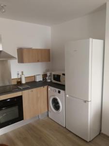 a kitchen with a white refrigerator and a dishwasher at Appartement sympa T2 in Alès