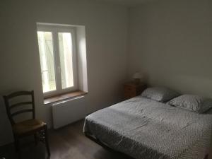 a bedroom with a bed and a window and a chair at Appartement sympa T2 in Alès