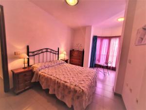 sypialnia z łóżkiem, komodą i oknem w obiekcie Cristi Puerto Santiago Apartment by HRTenerife Net w mieście Puerto de Santiago