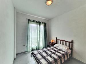 sypialnia z łóżkiem i oknem w obiekcie Cristi Puerto Santiago Apartment by HRTenerife Net w mieście Puerto de Santiago