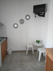 a kitchen with two tables and a tv on the wall at Vigla House in Sykia Chalkidikis