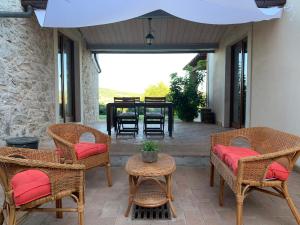 un patio con sedie in vimini e un tavolo con sala da pranzo di Il Casale delle Mura a Saturnia