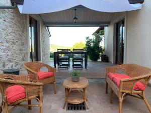 un patio con sillas de mimbre y una mesa con comedor. en Il Casale delle Mura, en Saturnia