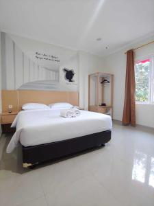 um quarto com uma cama grande num quarto em Heritel Urban Hostel em Jakarta