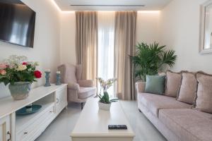 a living room with a couch and two chairs at Narya Luxury Apartment in Agios Rokkos