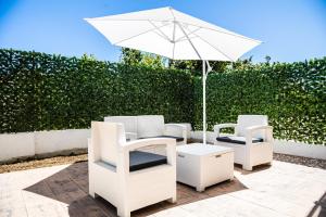 two white chairs and an umbrella on a patio at Ninfa Marina in Termoli
